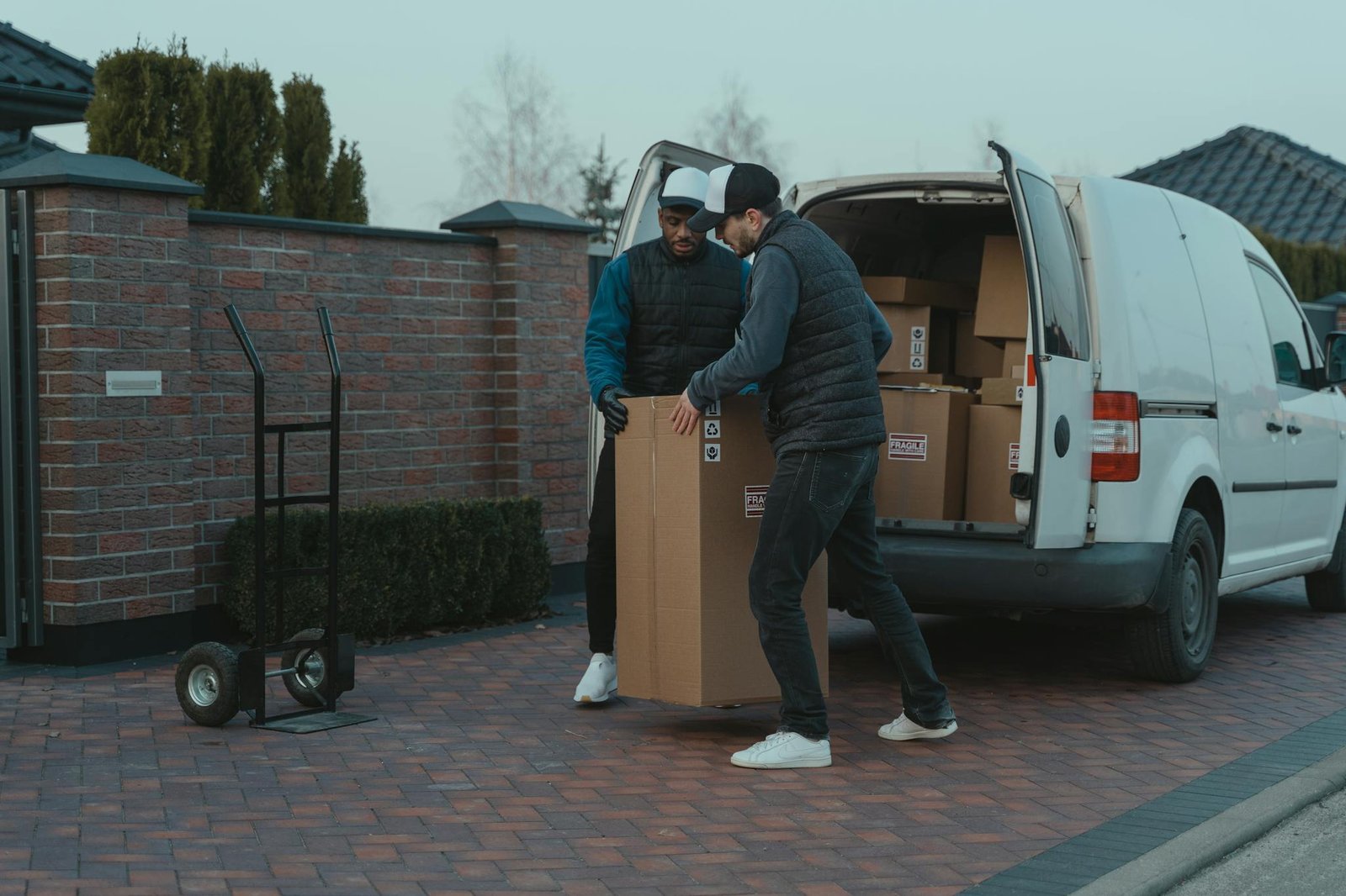 Delivery team handling packages from van in suburban area.